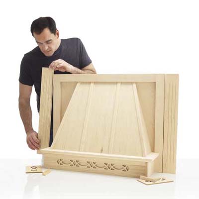 Man assembling the range hood cover.