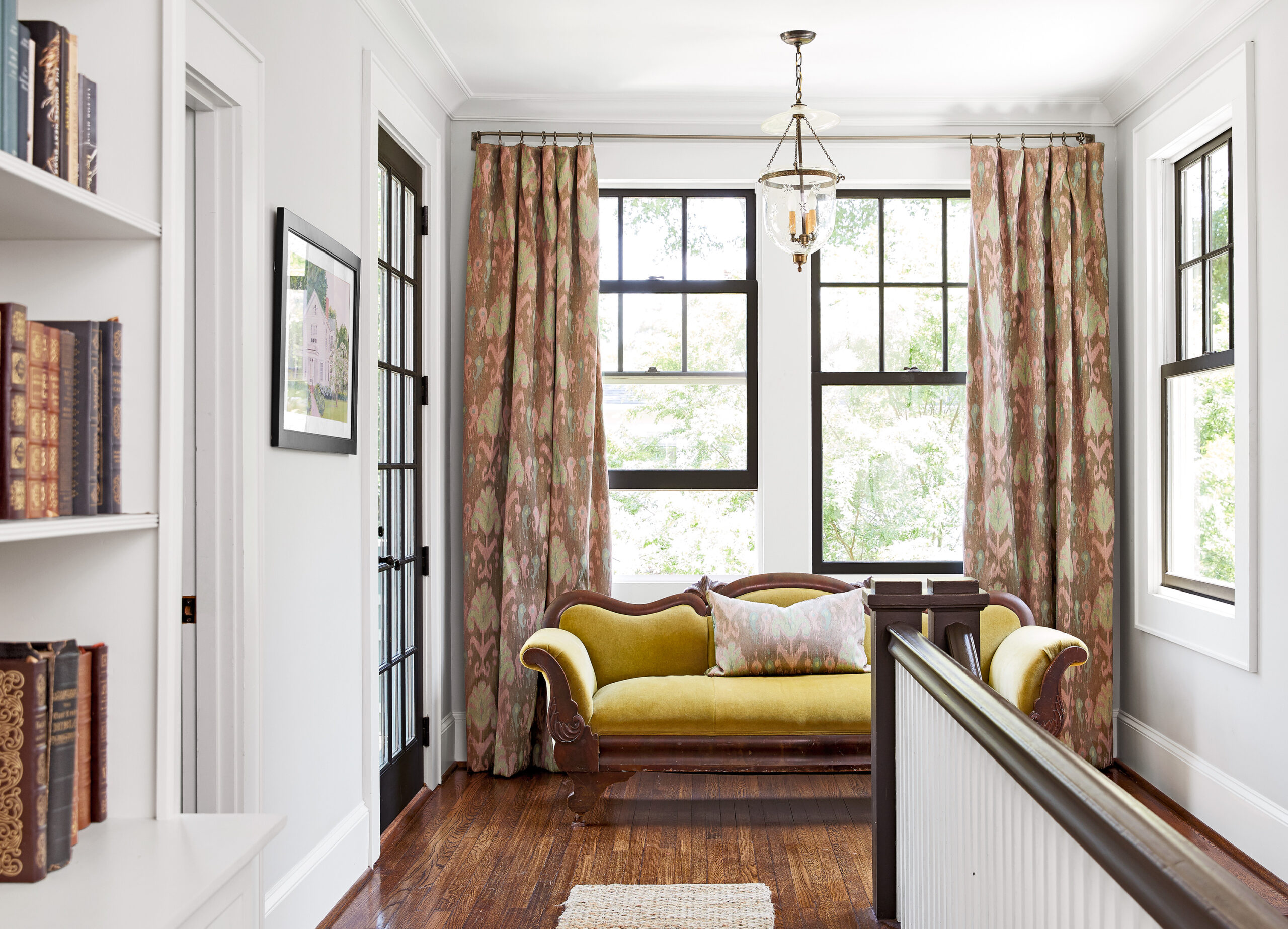 Stair landing area with multiple windows and a green couch.