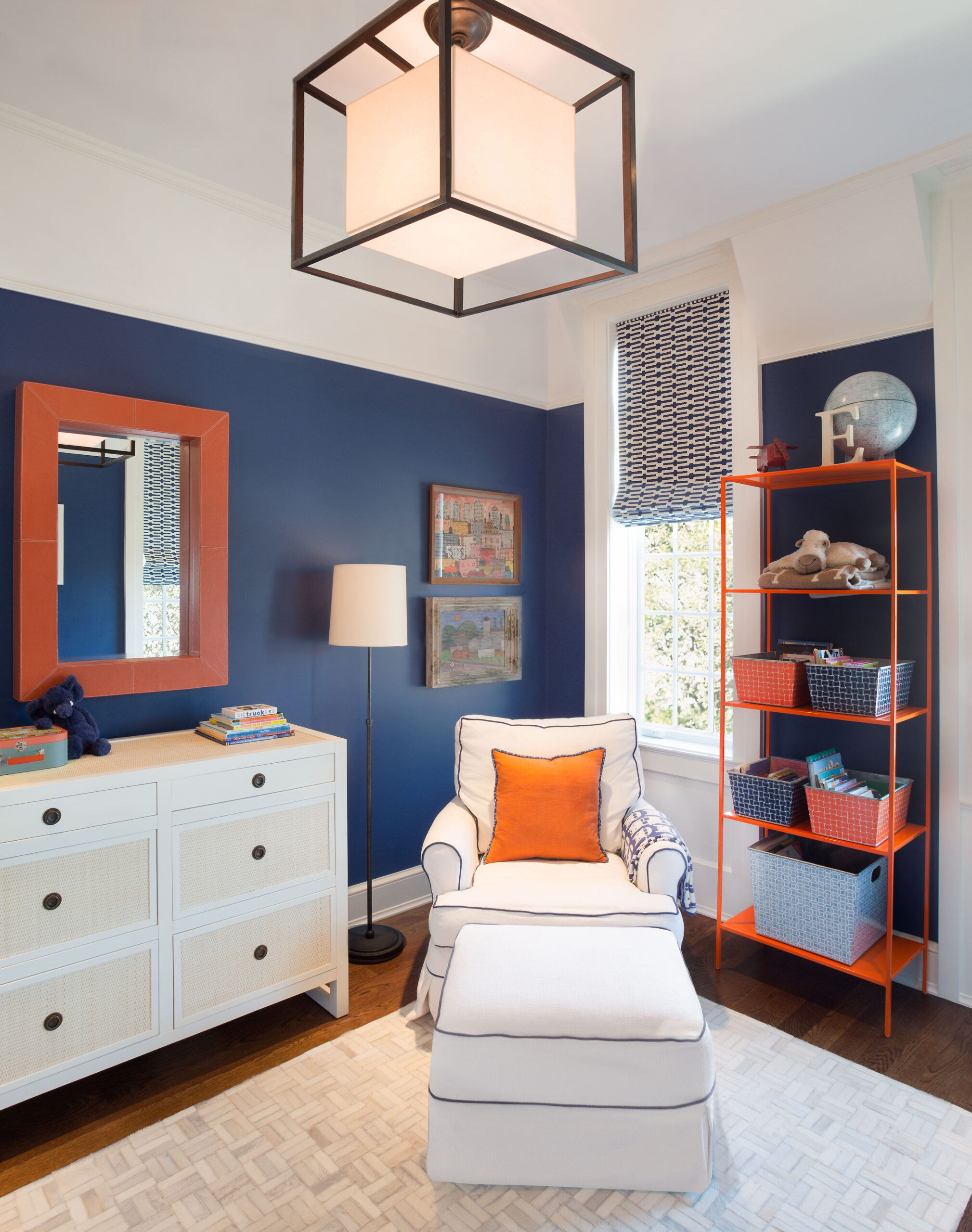 A room with a large cube shaped light fixture and a blue and orange color scheme.