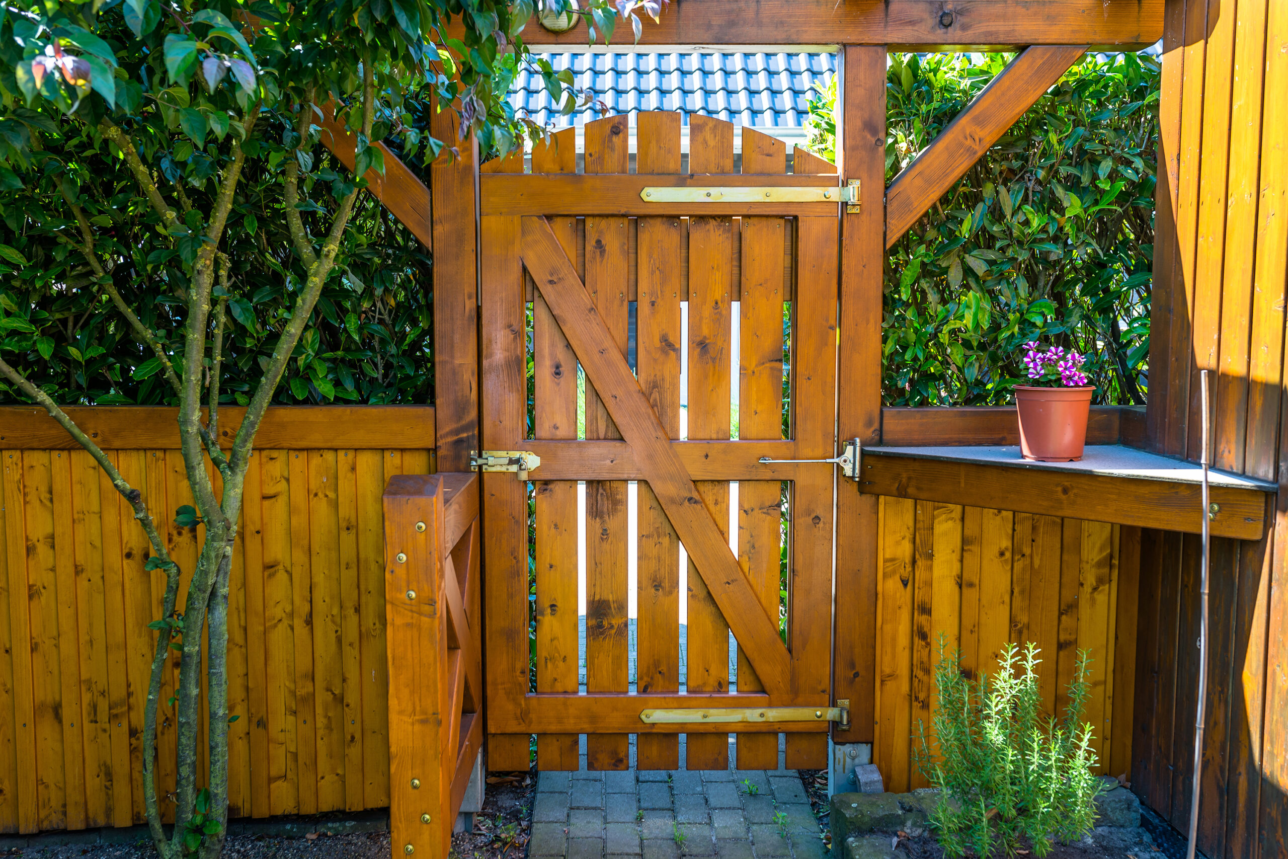 A stained wood fence with a swinging door.